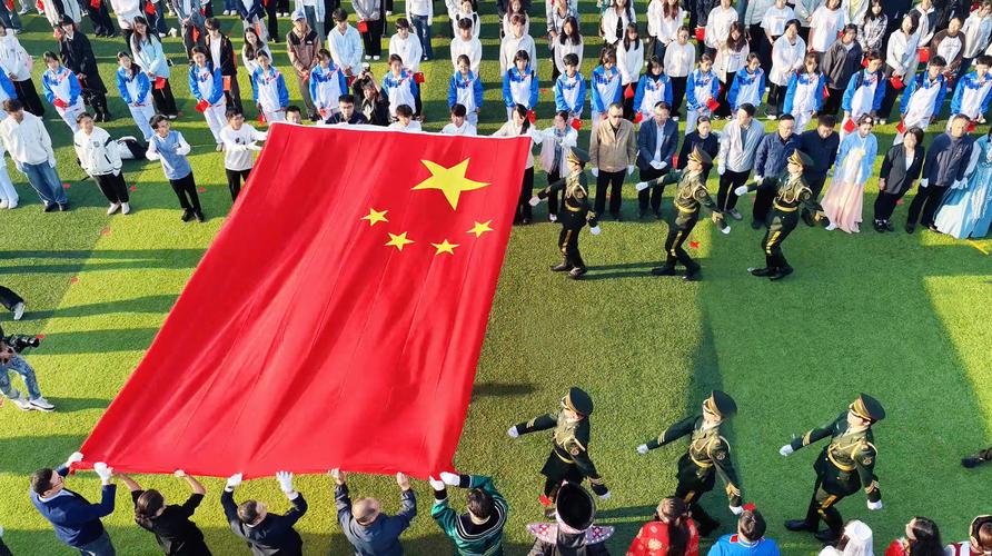 升旗仪式上,我们全校师生怀着